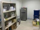 Well-organized storage room with shelving units and modern refrigerator