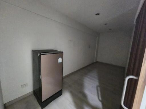 Spacious unfurnished living room with large refrigerator
