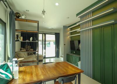 Modern living and dining area with green accent wall