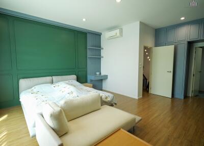 Spacious bedroom with unique accent wall, modern furniture, and natural light