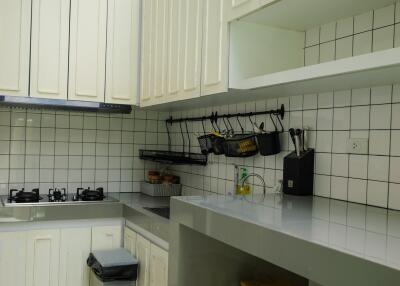 Modern kitchen with white cabinets, gas stove, and skylight