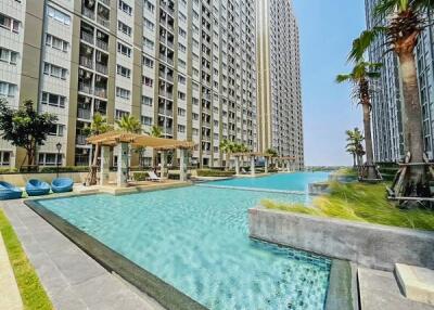Luxurious condominium complex with large swimming pool and stylish lounging areas