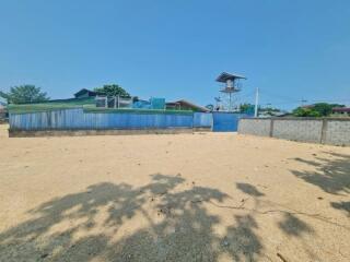 Spacious sandy lot with surrounding fence under a clear blue sky