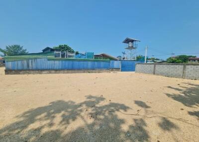 Spacious sandy lot with surrounding fence under a clear blue sky