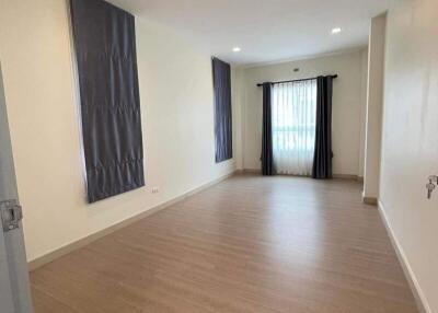 Spacious and well-lit empty living room with wooden flooring