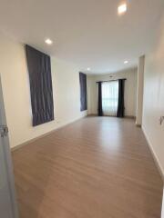 Spacious and well-lit empty living room with wooden flooring