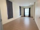 Spacious and well-lit empty living room with wooden flooring