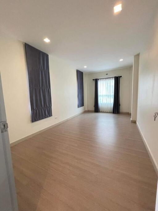 Spacious and well-lit empty living room with wooden flooring