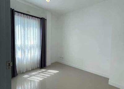 Spacious and brightly lit empty bedroom with large window