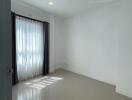 Spacious and brightly lit empty bedroom with large window