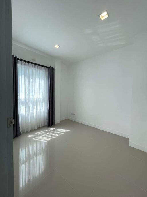 Spacious and brightly lit empty bedroom with large window