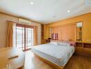 Spacious bedroom with natural lighting and wooden furnishings