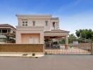 Elegant two-story house with a secure gate and landscaped front yard