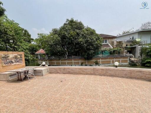 Spacious outdoor patio area with brown tiling and seating arrangement