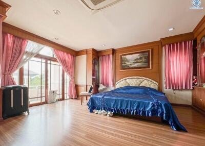 Spacious bedroom with large windows and wooden flooring