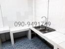 Basic kitchen interior with stainless steel sink and tiled countertops