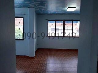 Spacious living room with large windows and terracotta tiled flooring