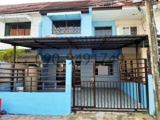 Blue two-story residential house with gated entrance