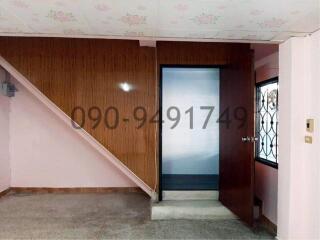 Spacious entryway with wooden paneling and elegant staircase