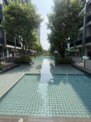 Swimming pool surrounded by residential buildings with lush green trees