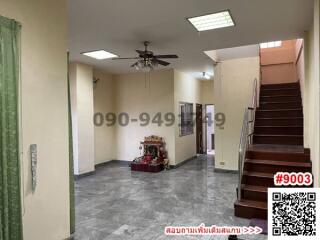 Spacious living room with staircase and tiled flooring