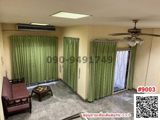 Spacious living room with green curtains and air conditioning