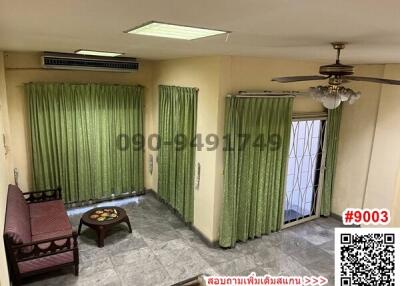 Spacious living room with green curtains and air conditioning