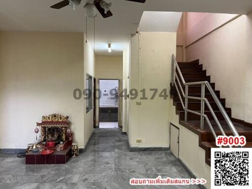 Interior of a spacious living room with staircase and ceiling fan