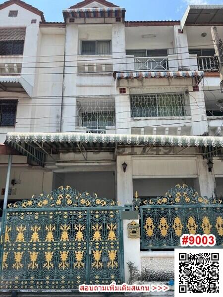 Exterior view of a multi-story residential building with ornate gate