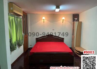 Spacious bedroom with large wooden bed and air conditioning