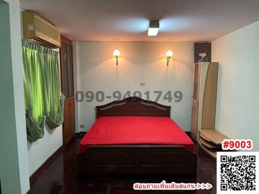 Spacious bedroom with large wooden bed and air conditioning