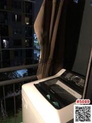 Compact balcony with washing machine and city view