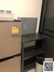 Compact kitchen corner with refrigerator and storage shelves