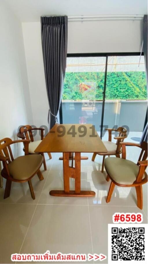 Bright dining room with wooden table and chairs, large window and modern tile flooring