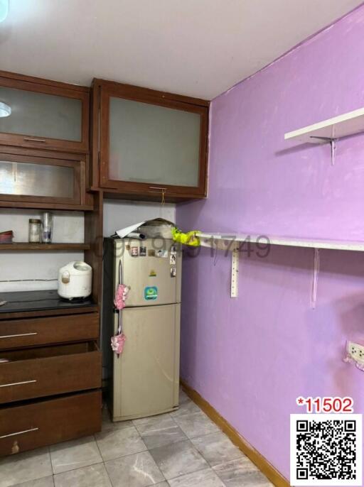 Compact kitchen space with purple walls and wooden cabinets
