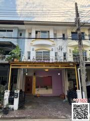 Exterior view of a residential townhouse with distinct purple and yellow accents