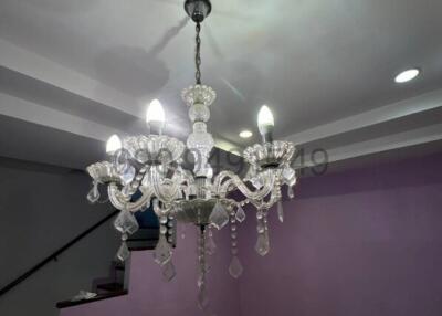 Elegant chandelier in a modern living room with purple walls