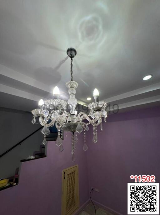 Elegant chandelier in a modern living room with purple walls