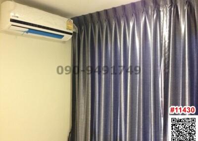 Bedroom with blue curtains and an air conditioning unit