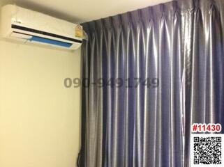 Bedroom with blue curtains and an air conditioning unit
