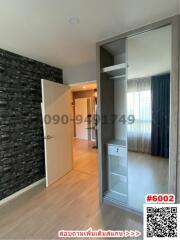 Modern bedroom in apartment with built-in wardrobe and stylish stone wall