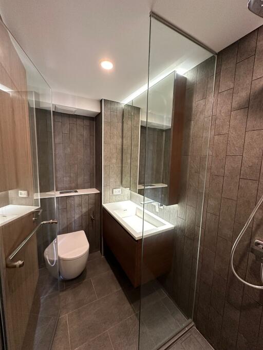 Modern bathroom with glass shower and wooden cabinetry
