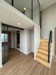 Modern interior with wooden staircase and glass railing