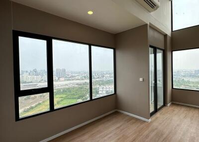 Spacious living room with large windows offering city views