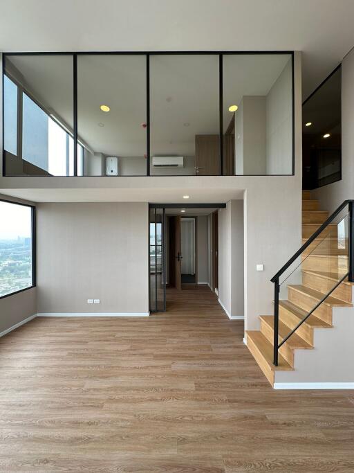 Modern duplex apartment interior with wooden stairs and high ceiling