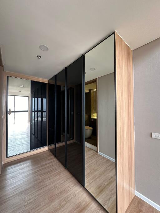 Modern bedroom with mirrored wardrobe and wooden flooring