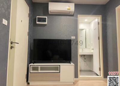 Modern living room with wall mounted TV and adjacent bathroom