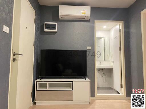 Modern living room with wall mounted TV and adjacent bathroom