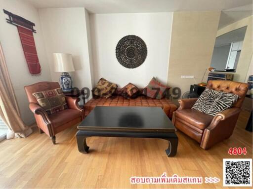 Spacious living room with leather sofa and wooden furniture