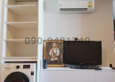 Compact living space with mounted TV, washing machine, and air conditioner